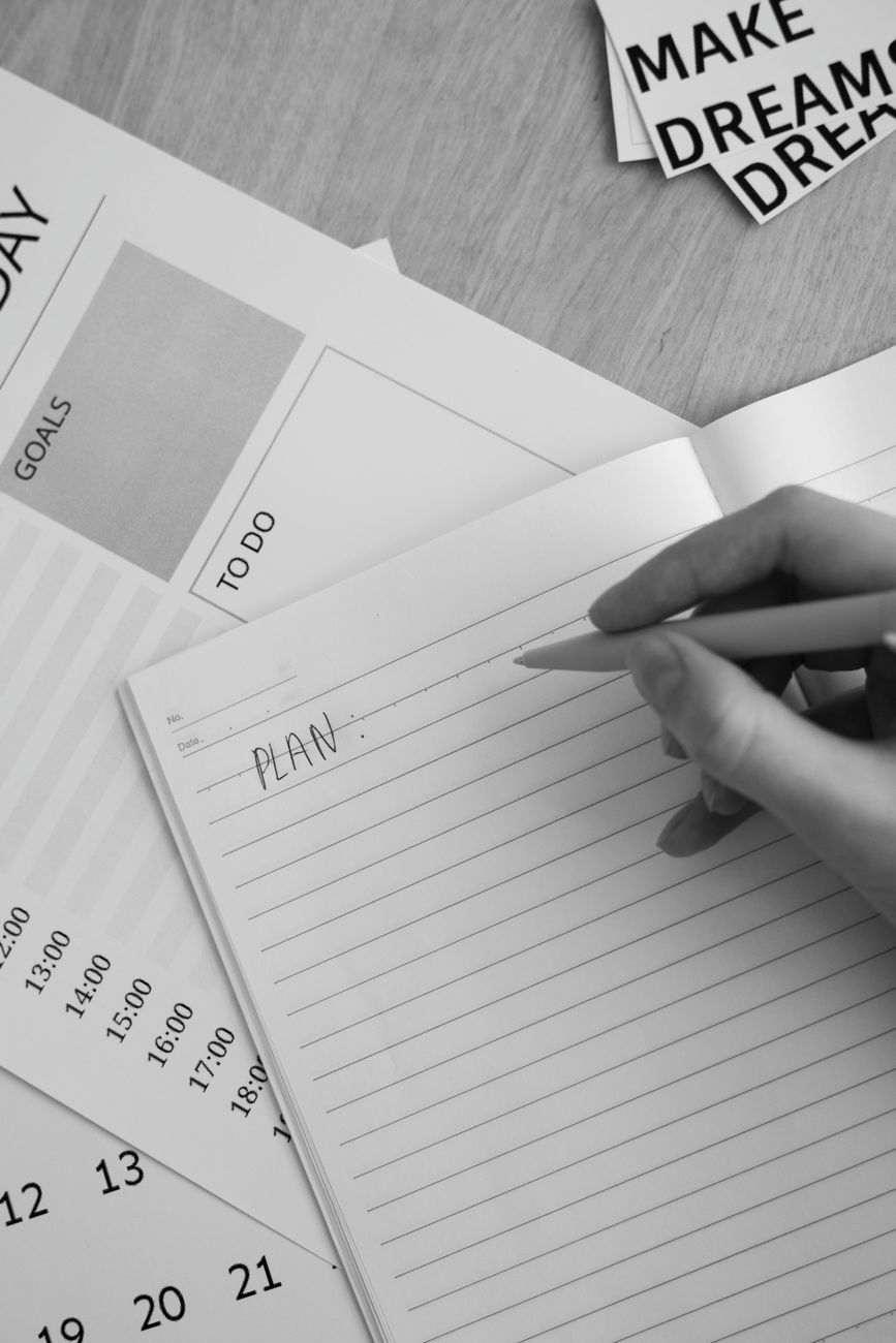 grayscale photo of a person s hand holding a pen